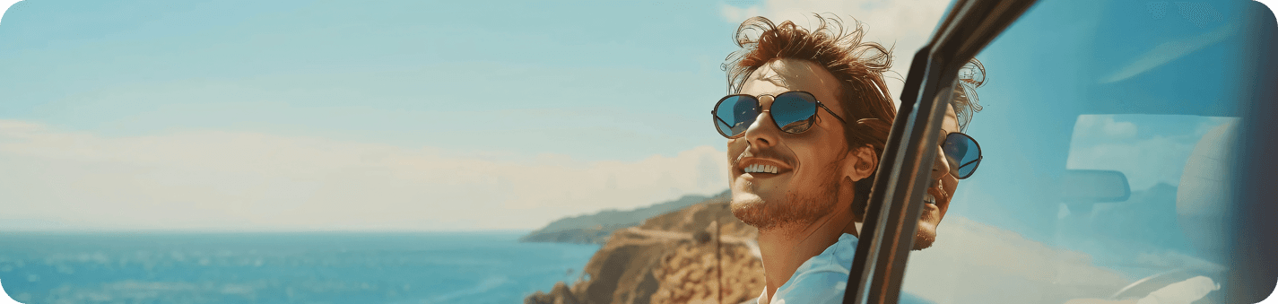 Smiling traveller looking out of a car window over the Cretan coast